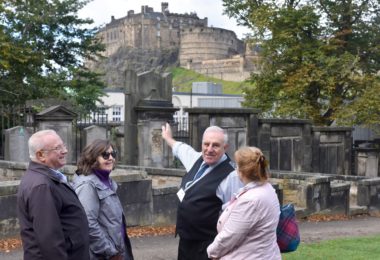guide showing a group of people the kirkyard