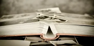an unfolded book stacked with old photographs
